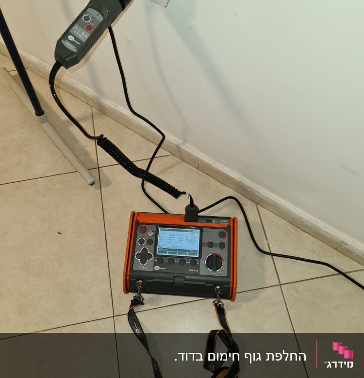 מכשיר בדיקה חשמלי מחובר לשקע בקיר